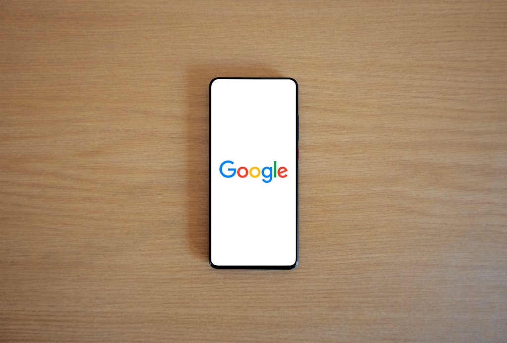 A smartphone displaying the GOOGLE logo for a blog post on best Google Business practice for 2024-2026